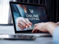 Laptop mit geöffneter Online-Shopping-Website, Hand zeigt auf den Bildschirm.