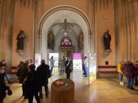 Blick auf den Eingangsbereich der Kirche mit LED-Ausstellung – leuchtende Informationsstelen lenken die Aufmerksamkeit.