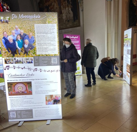 Nahaufnahme eines der ausgestellten LED-Displays mit QR-Codes und thematischen Informationen zur Männerseelsorge.