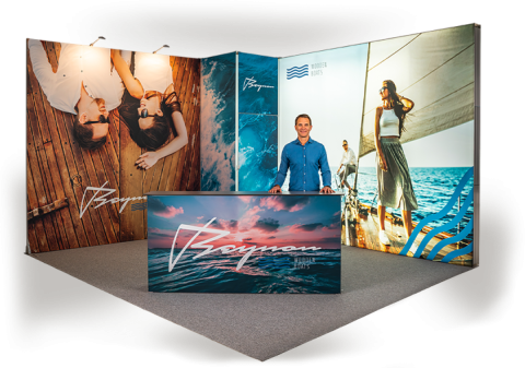 Messestand-Design für Beymon Yachts. Messestand mit Theke und großflächigen Bannern, die maritime Motive und Models auf einem Boot zeigen.