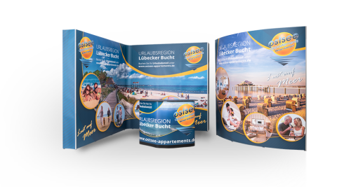 Messestand mit drei Ostsee-Appartements-Displays in blau-gelbem Design für die Tourismusbranche, kombiniert zu einem kompletten Messestand mit Transportkoffertheke.