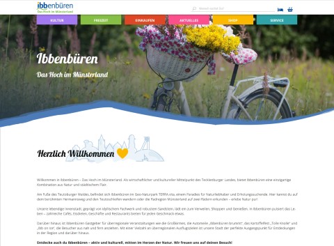 Screenshot des neuen barrierefreien Webauftritts des Stadtmarketings Ibbenbüren mit Startseite, Navigation und Foto eines Blumenfahrrads vor grüner Wiese; Themenbereiche wie Kultur, Freizeit, Einkaufen, Aktuelles, Shop und Service sind übersichtlich strukturiert