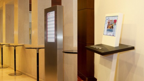 Zwei schlanke Stelen mit digitalen Displays zur Anzeige von Raumbelegung und Besucherinformationen im eleganten Flur des Marriott Hotels Berlin.