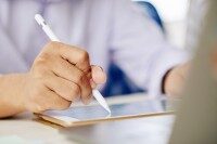 Person unterschreibt mit digitalem Stift auf Tablet.