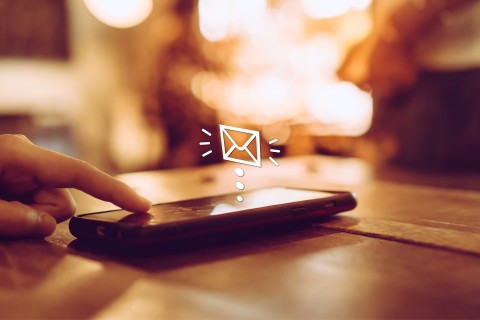 Finger berührt Smartphone-Bildschirm, animiertes Symbol einer Nachrichteneingangsbuchse als Hinweis auf Push-Benachrichtigungsfunktion.