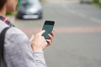 Person nutzt Smartphone zur Standorterfassung mit Karten-Funktion im Freien.