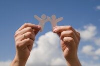 Zwei Personen im Gewächshaus prüfen Pflanzen und machen Notizen auf einem Block, Symbol für eine App für Landwirtschaft und Gartenbau zur digitalen Dokumentation und Organisation.