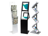 Drei moderne Prospektständer in Weiß, Schwarz und Silber, bestückt mit Magazinen und Flyern