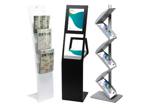 Prospektständer und Kataloghalter – stilvolle Präsentationssysteme für Broschüren und Flyer Drei moderne Prospektständer in Weiß, Schwarz und Silber, bestückt mit Magazinen und Flyern