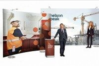 Messestand mit Kombination aus gebogenen und geraden Textilwänden sowie Theke