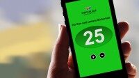App Display mit Sicherheitsanzeige 25 Person hält Smartphone mit grüner App Oberfläche, zeigt