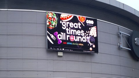 Werbeplakat an Gebäudewand mit dem Text 