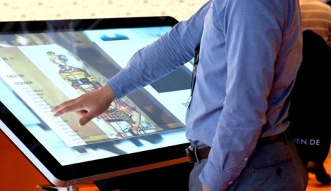 Ein Mann bedient einen großen Touchscreen mit einer digitalen Benutzeroberfläche.