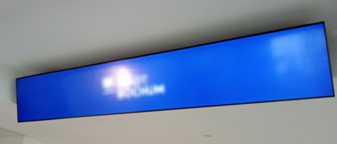 Breitformatiges Display mit Rückenabdeckung an der Decke montiert für saubere Kabelführung