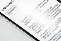 Nahaufnahme eines Mobiltelefons, das eine Webseite mit Text anzeigt