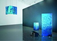 Blauer Leuchtwürfel und rechteckige Leuchtstele mit Unterwasser-Motiv in modernem Raum